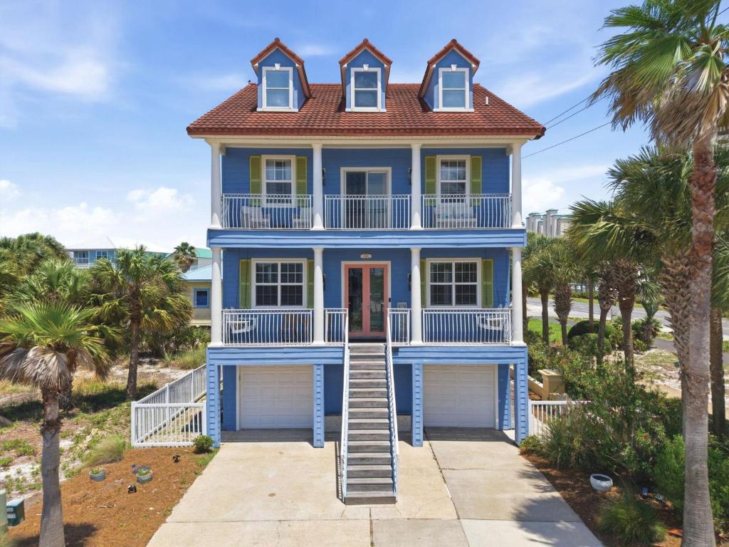a blue house on the beach with palm trees at Periwinkle Paradise in Navarre
