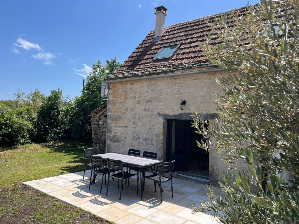 a table and chairs in front of a building at Les maisons de Palis in Salvagnac-Cajarc