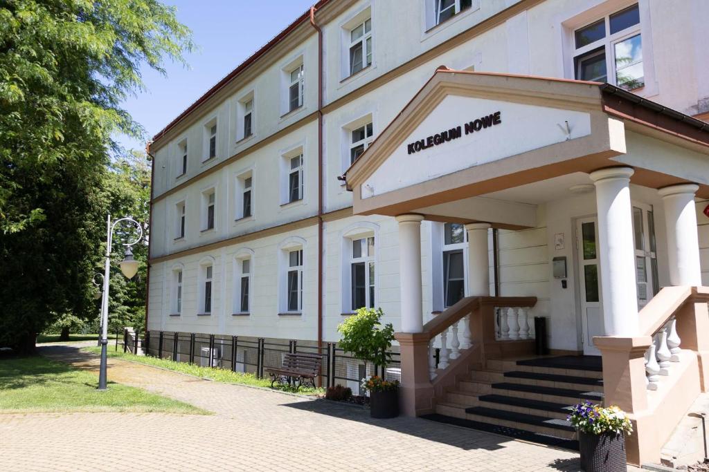 a white building with a sign that reads hotel mum at Kolegium Nowe PANS - hostel in Przemyśl