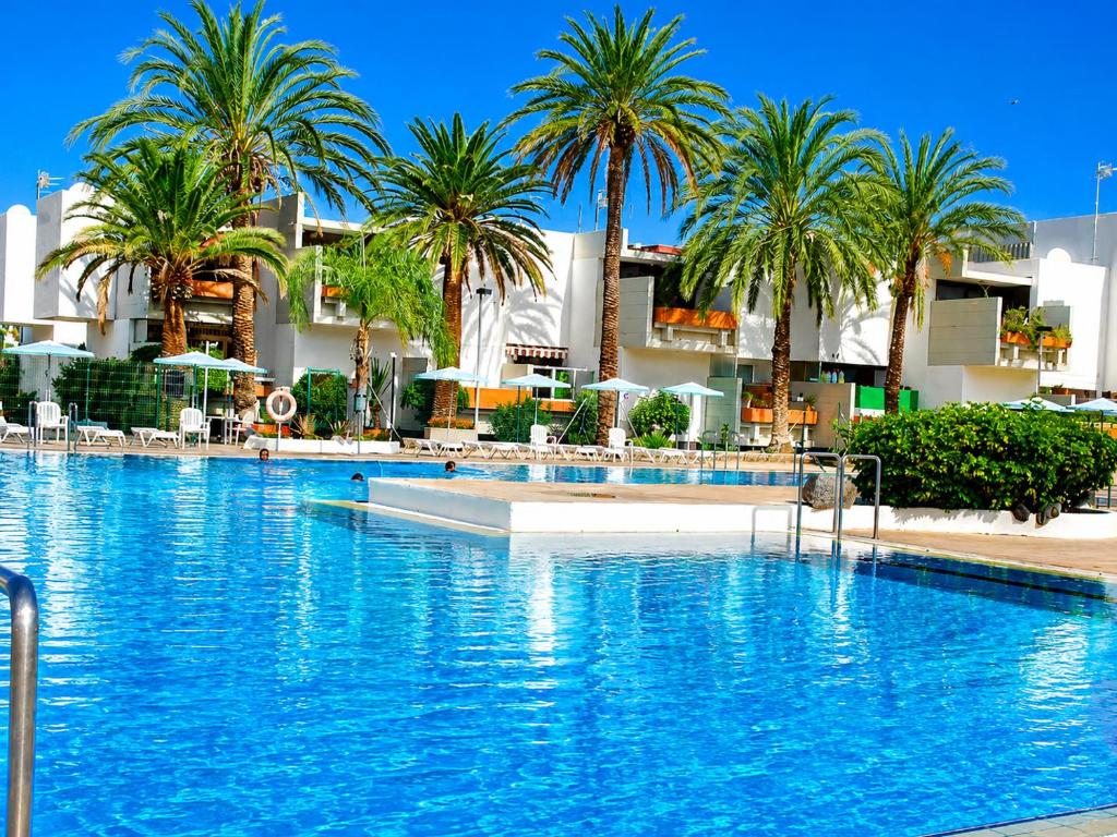 a large swimming pool with palm trees and buildings at Primavera Pool Paradise in Arona