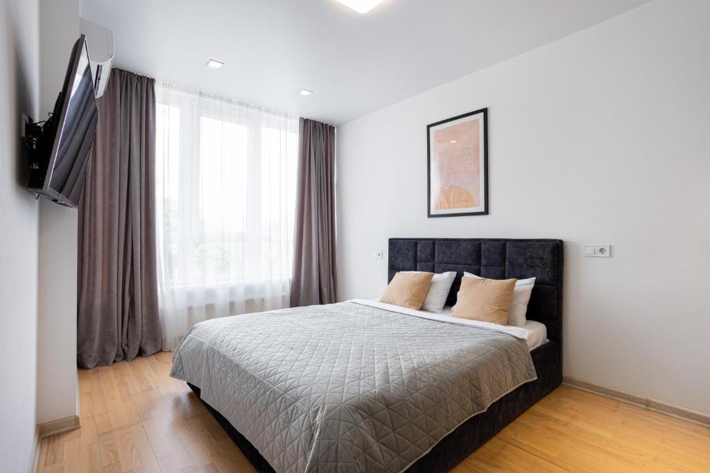 a bedroom with a bed and a large window at Nyvky Like Home - Studio - apt 35 in Kyiv