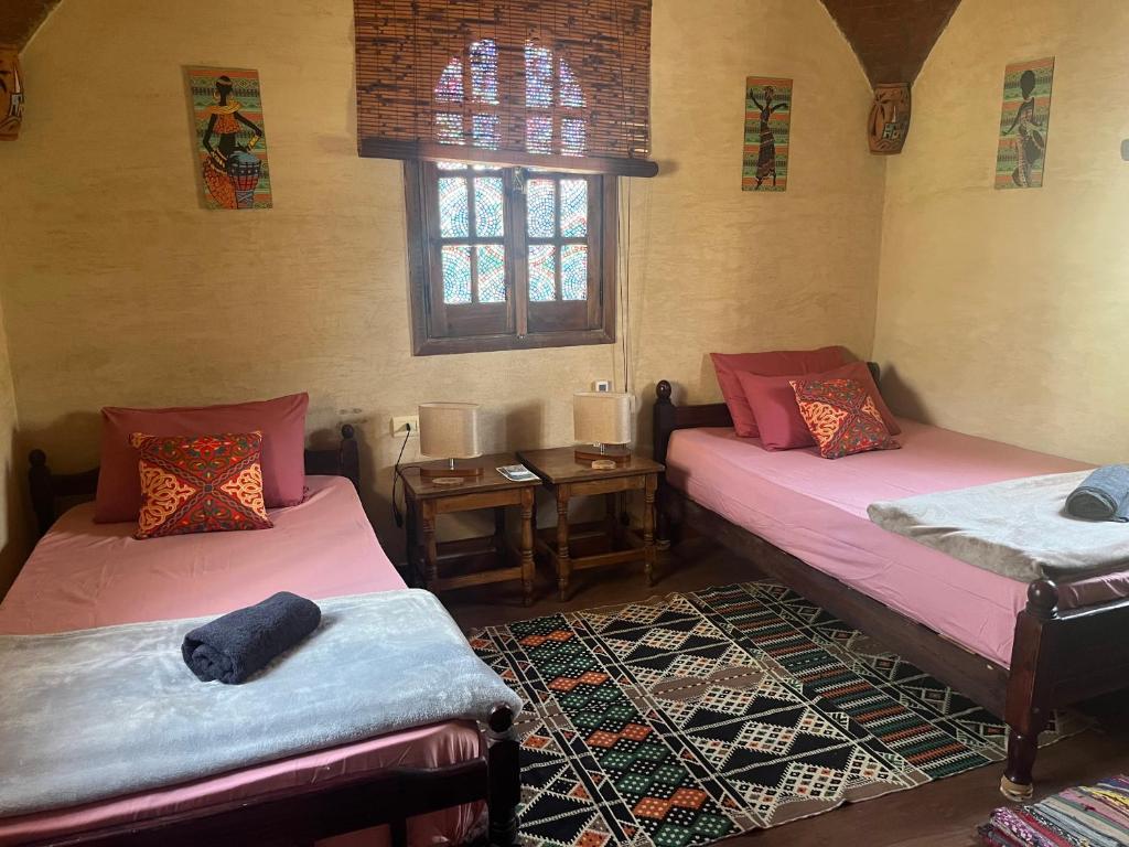 a room with two beds and a window at Siwa Spot - Authentic Siwan Room with Private Patio in Siwa