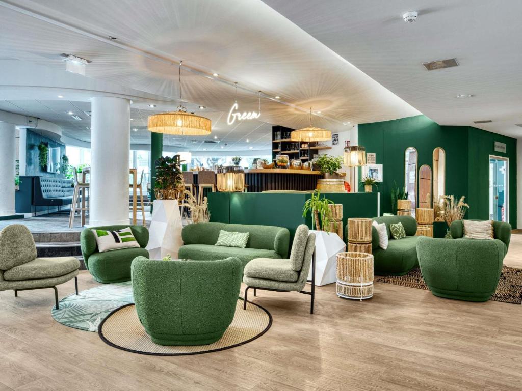 a lobby with green furniture and green walls at Novotel Paris Charenton le Pont in Charenton-le-Pont