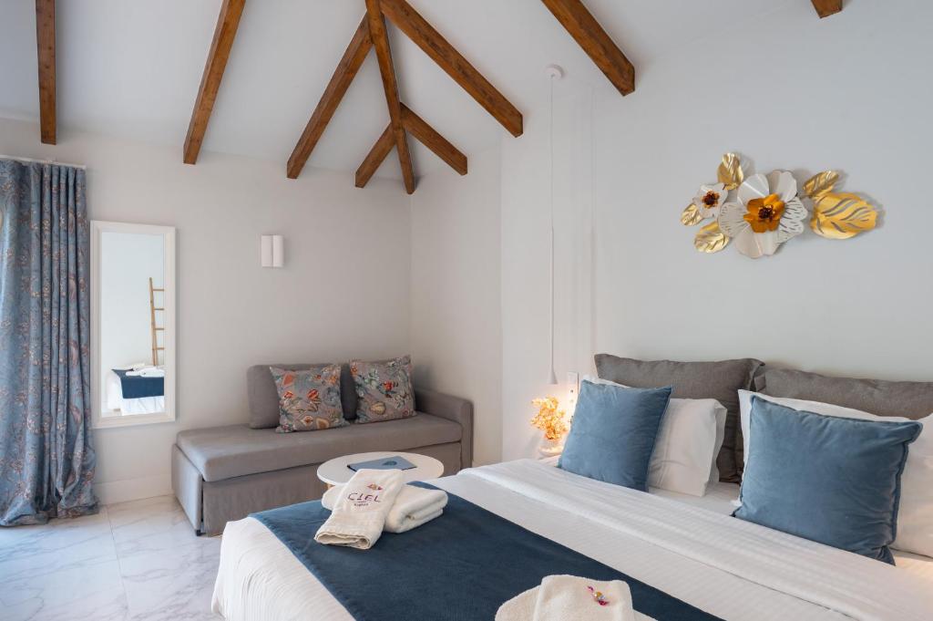 a bedroom with two beds and a couch at Ciel Suites Athens in Athens