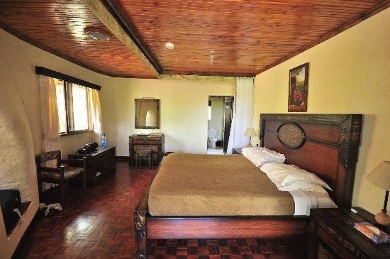 a bedroom with a large bed and a wooden ceiling at Nature Haven Mara Camp in Ololaimutiek