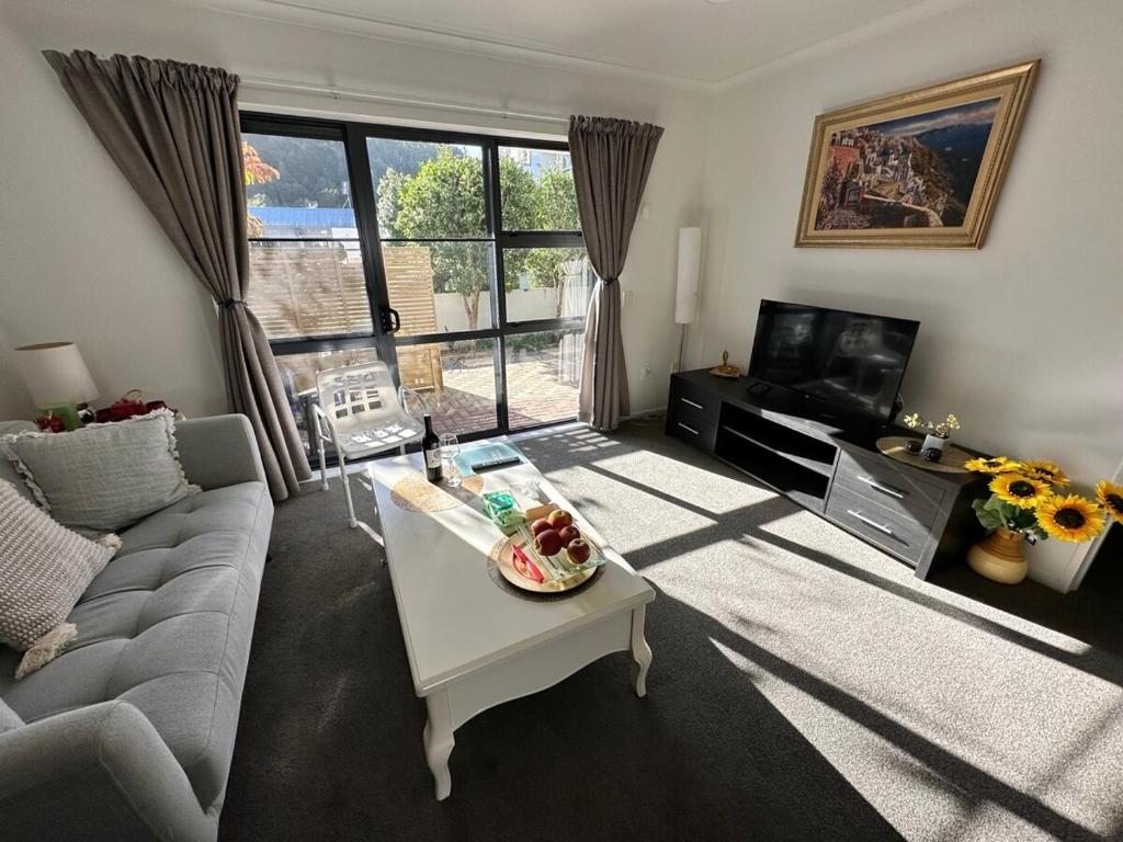a living room with a couch and a tv at warm, quiet and convenient ! in Auckland