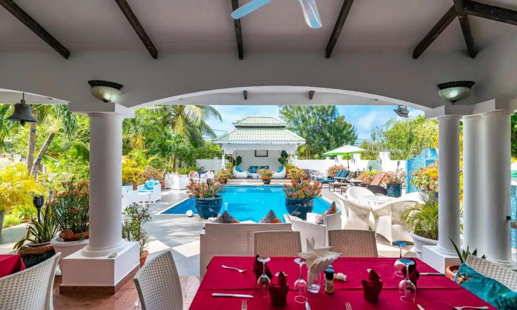 a patio with a table and chairs and a pool at Le Bonheur Villa in Victoria