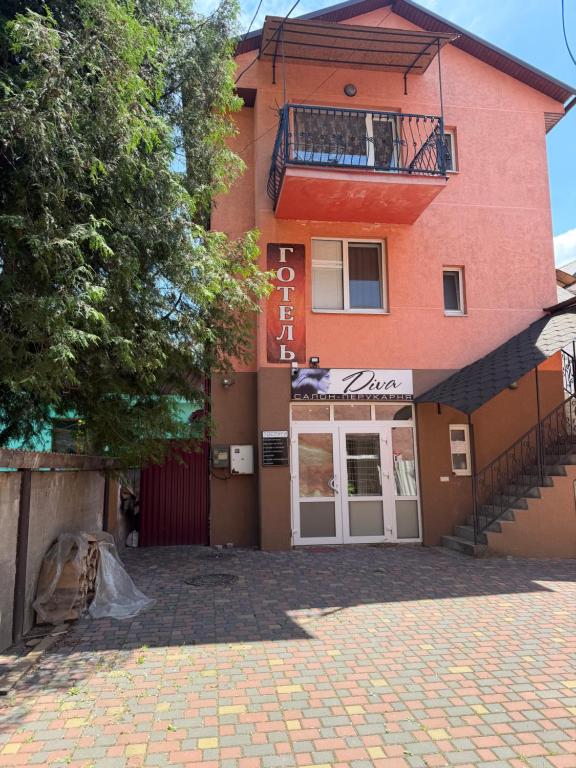 a red building with a balcony on top of it at Zatishok Guest House in Rakhiv