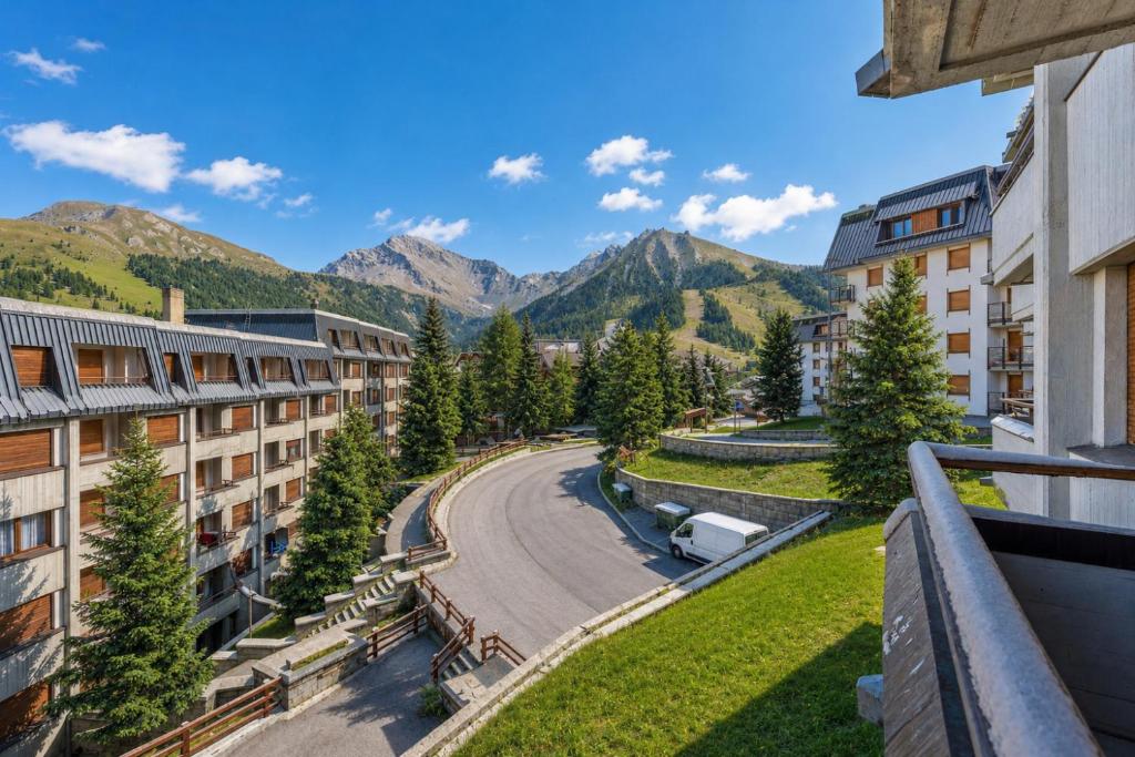 a view from the balcony of a resort with mountains at Hostdomus - Yellow Suite in Sestriere