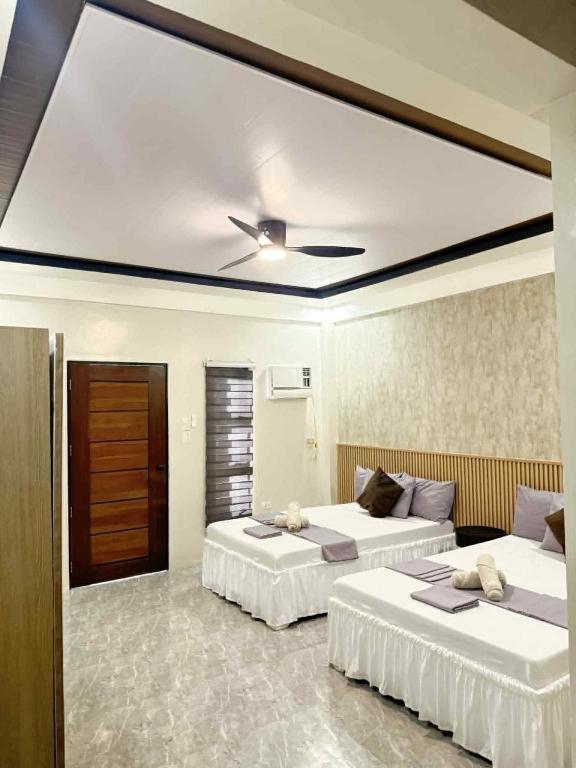 a bedroom with two beds and a ceiling at Reynaldos Place Corporation in Vigan