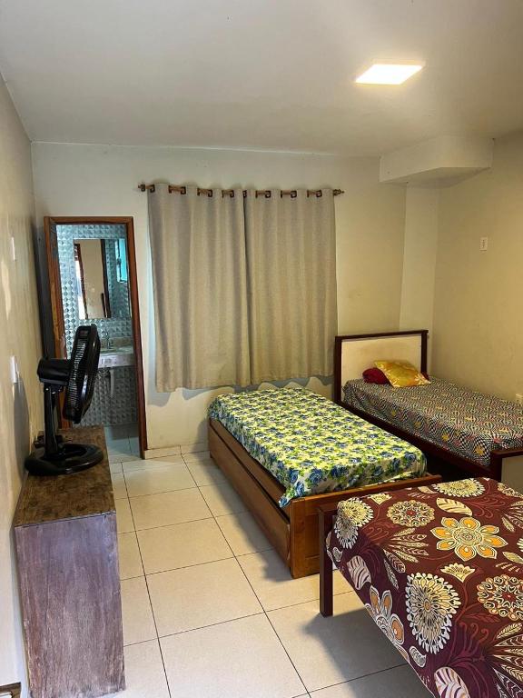 a room with two beds and a mirror at Hostel e Suites Caminho do Vale in Palmeiras