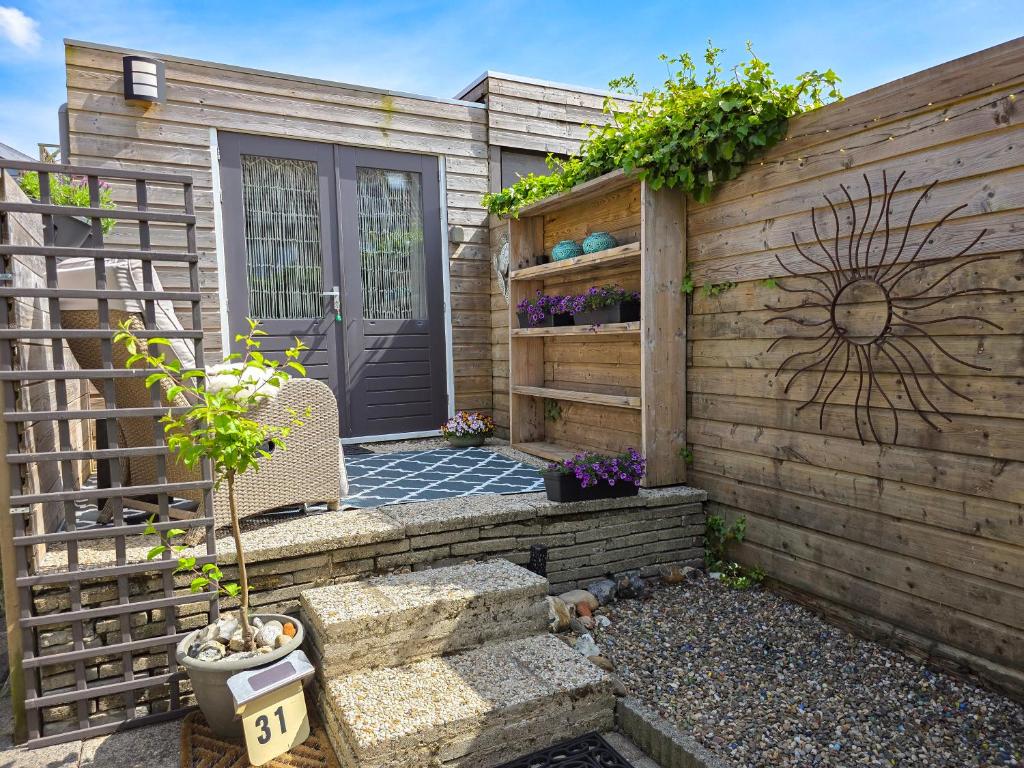 a wooden fence with a door and a patio at Vakantiewoning La Luna OK42 in Oostkapelle