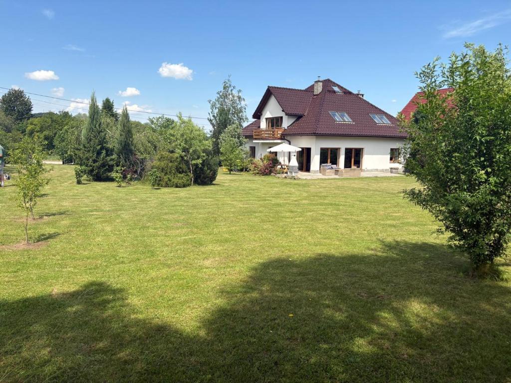 a large yard with a house in the background at Mirabelka Mucharz in Mucharz