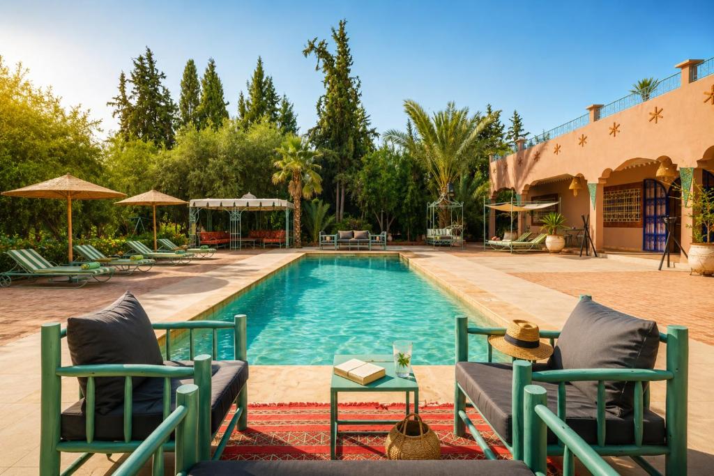 a swimming pool with two lounge chairs next to a building at Dar Salah - Eddine Oasis Pool & SPA in Marrakesh