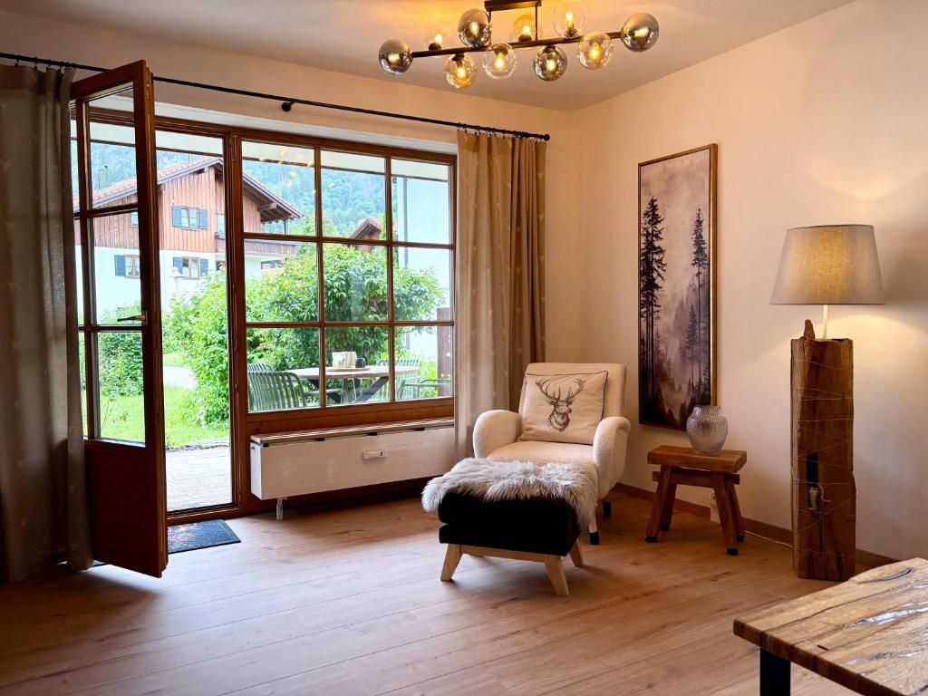 a living room with a chair and a large window at Ferienwohnung Vilstalstüble in Pfronten