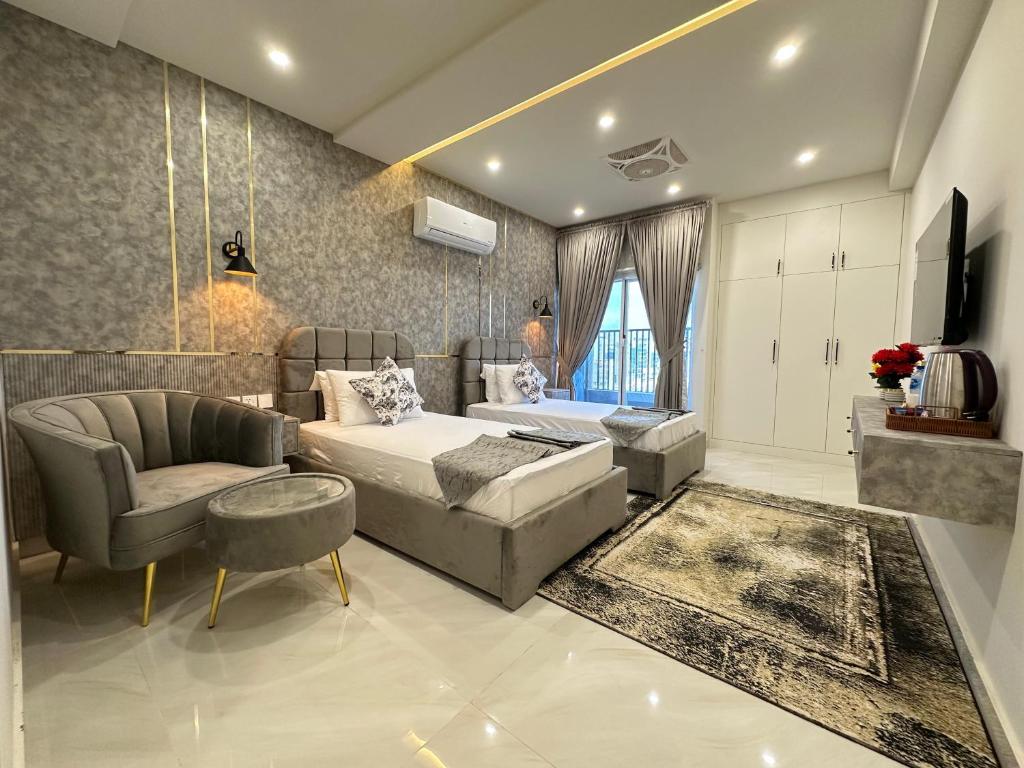 ein Schlafzimmer mit einem Bett, einer Couch und einem Stuhl in der Unterkunft Hotel Naim Wakeel in Islamabad