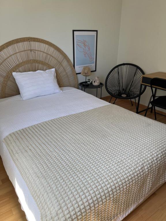 a bed in a bedroom with two chairs and a table at Mar de rosas in Carcavelos