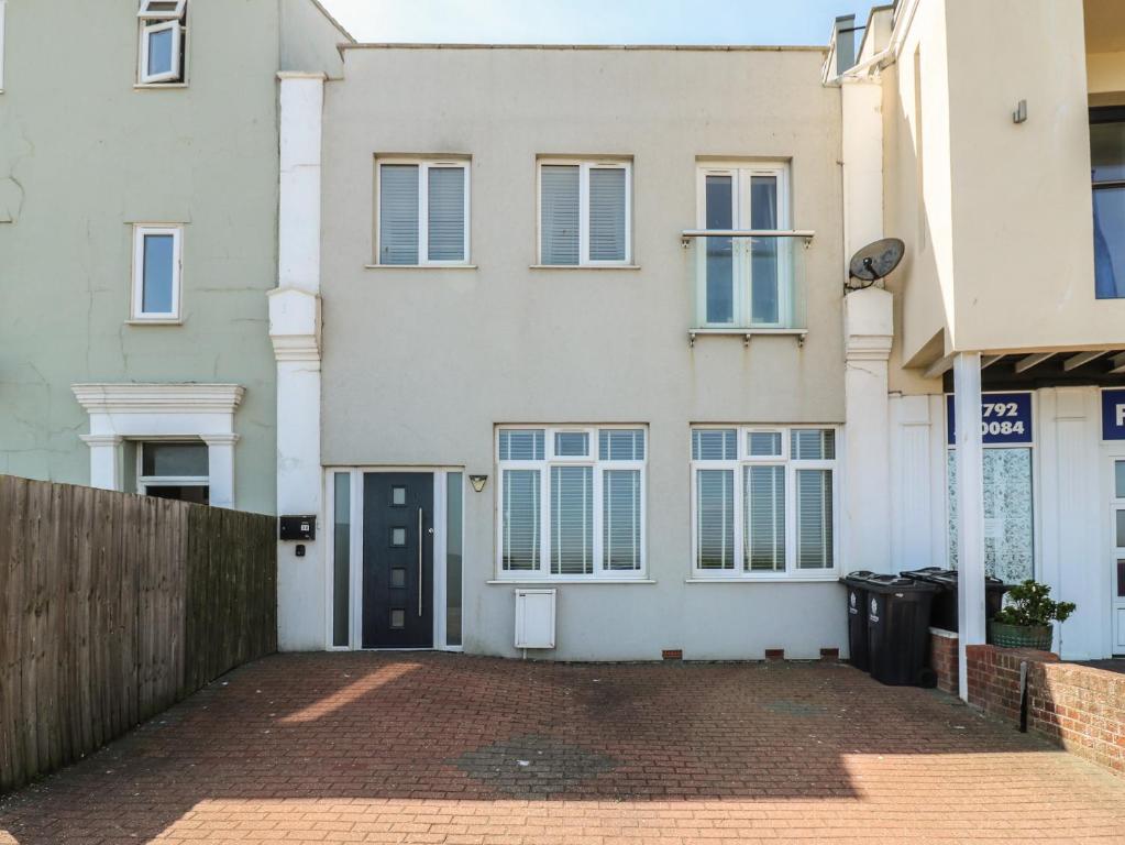 an empty street in front of a white house at 38 The Parade in Walton-on-the-Naze