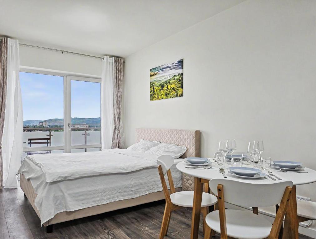 a bedroom with a bed and a table and chairs at Konstanzer 103 - 2 Room Ap & Parking- Iulius Mal - Smart TV - Highspeed Wi-Fi in Iaşi