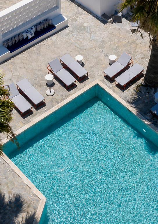 an overhead view of a swimming pool with chaise lounge chairs and a swimming pool at Soleil Hotel Paros in Drios