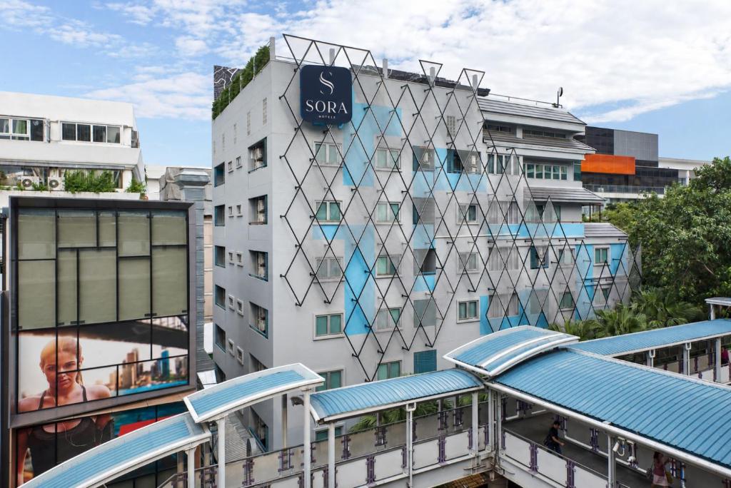 a building with a sign on the side of it at Sora Hotel Silom in Bangkok