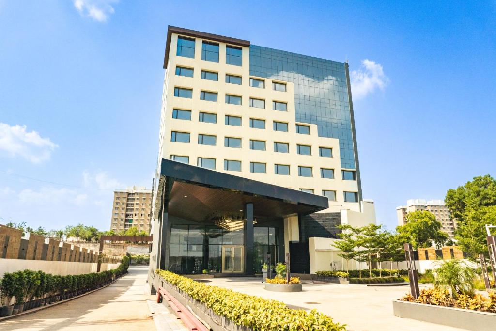 a tall white building with a lot of windows at Pride Plaza Indore in Indore