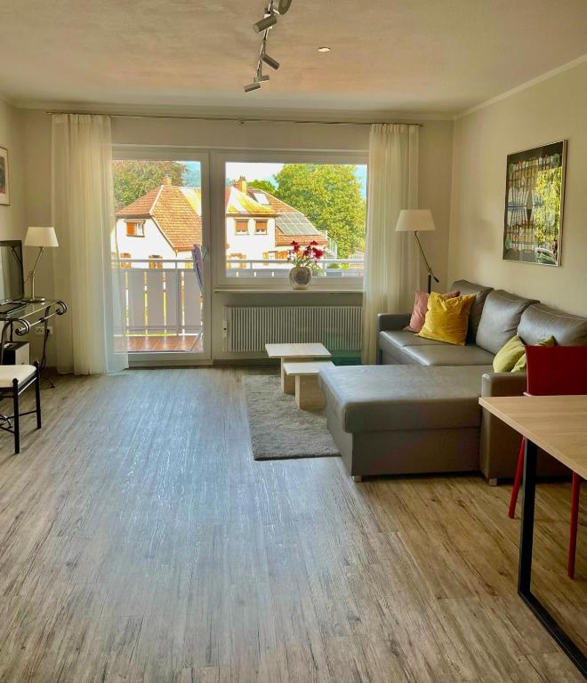 a living room with a couch and a large window at Ferienwohnung Flynn in Sonthofen
