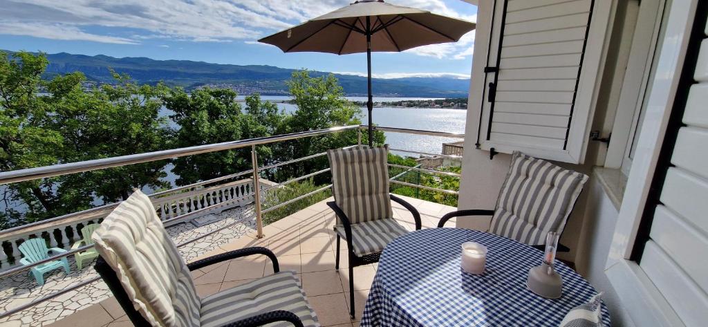a porch with a table and chairs and an umbrella at Apartment Sanjug in Šilo