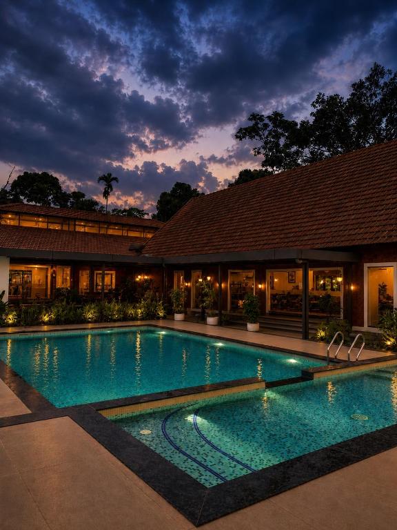 a large swimming pool in front of a building at DZION Resort Coorg in Gonikoppal