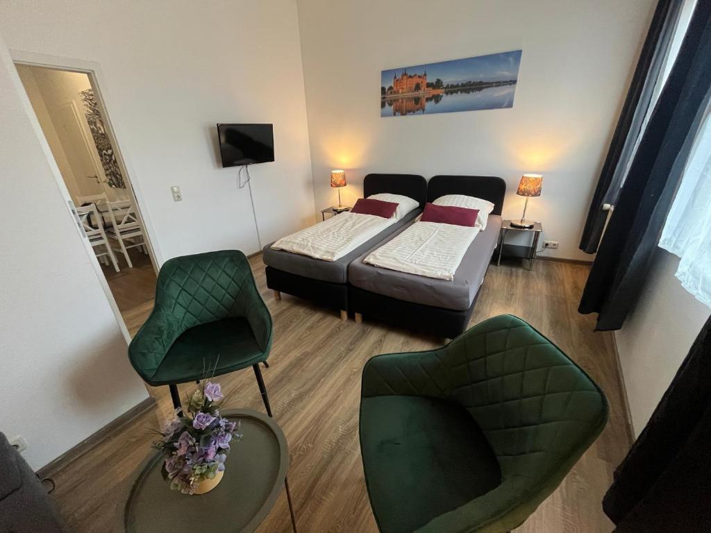 a room with two beds and a couch and chairs at Am Schloss 15 in Schwerin