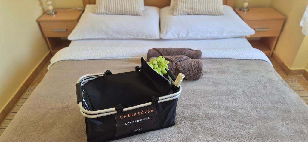 a black bag sitting on top of a bed at Bazsarózsa Apartmanok Csopak in Csopak