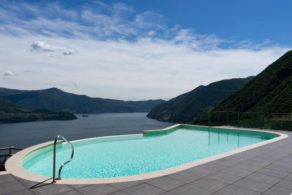 a swimming pool with a view of a river and mountains at Le Sirene in Parzanica