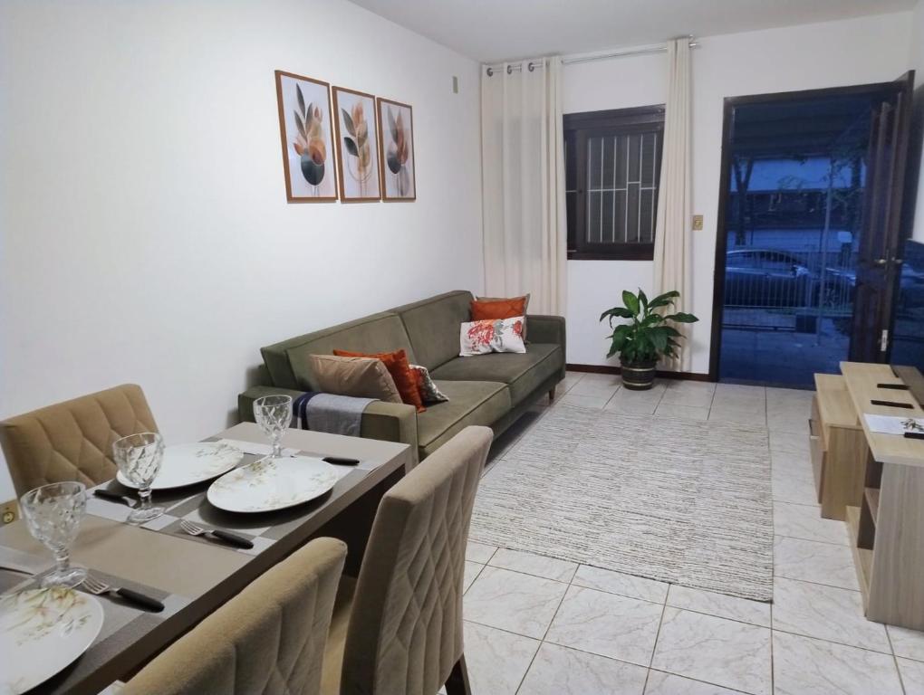 a living room with a couch and a table and chairs at casa top proximo Fenac NH in Novo Hamburgo