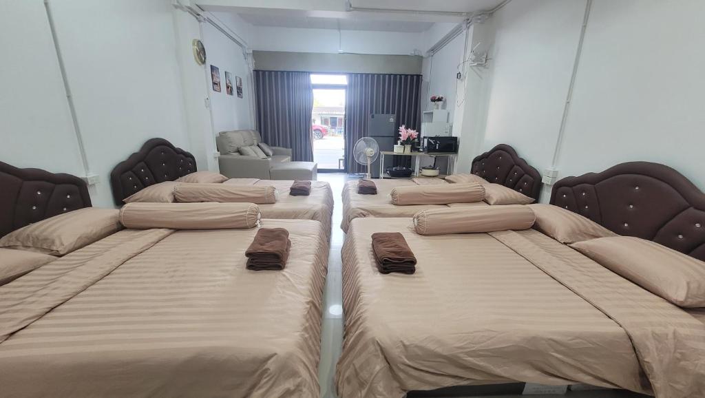 a room with three beds in a room at beMyGuest Bangsaen in Ban Thai Don (1)