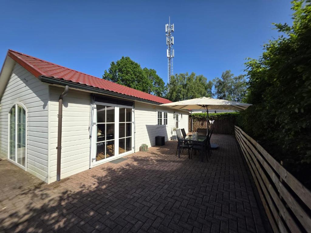 a patio with a table and an umbrella next to a building at Huisje 11 in Enschede