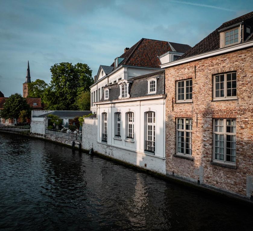 a building on the side of a river at Molenmeers Boutique Guesthouses in Bruges