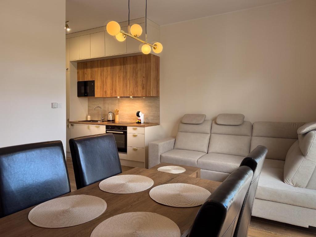 a living room with a table and a couch at Rezydencja De Rosse in Jastrzębia Góra