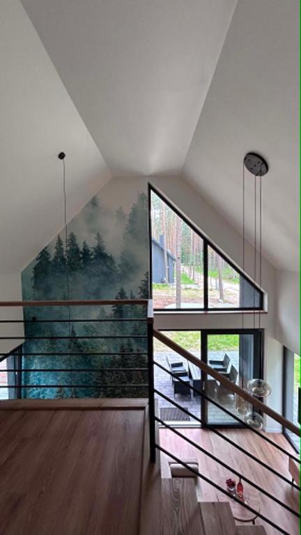 a staircase in a house with a large window at Roztoczańska Stodoła in Majdan Sopocki