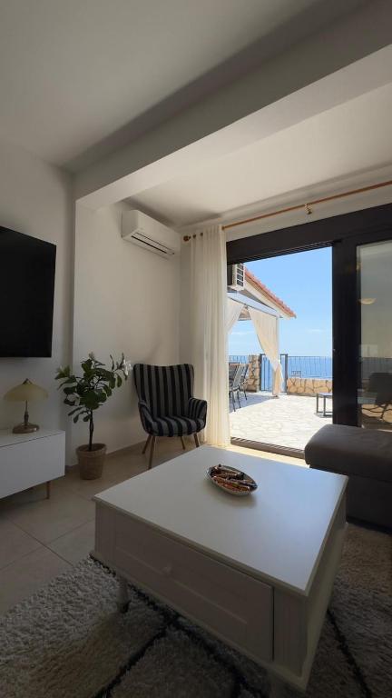 a living room with a table and a view of the ocean at Luka private beach in Dobra Voda