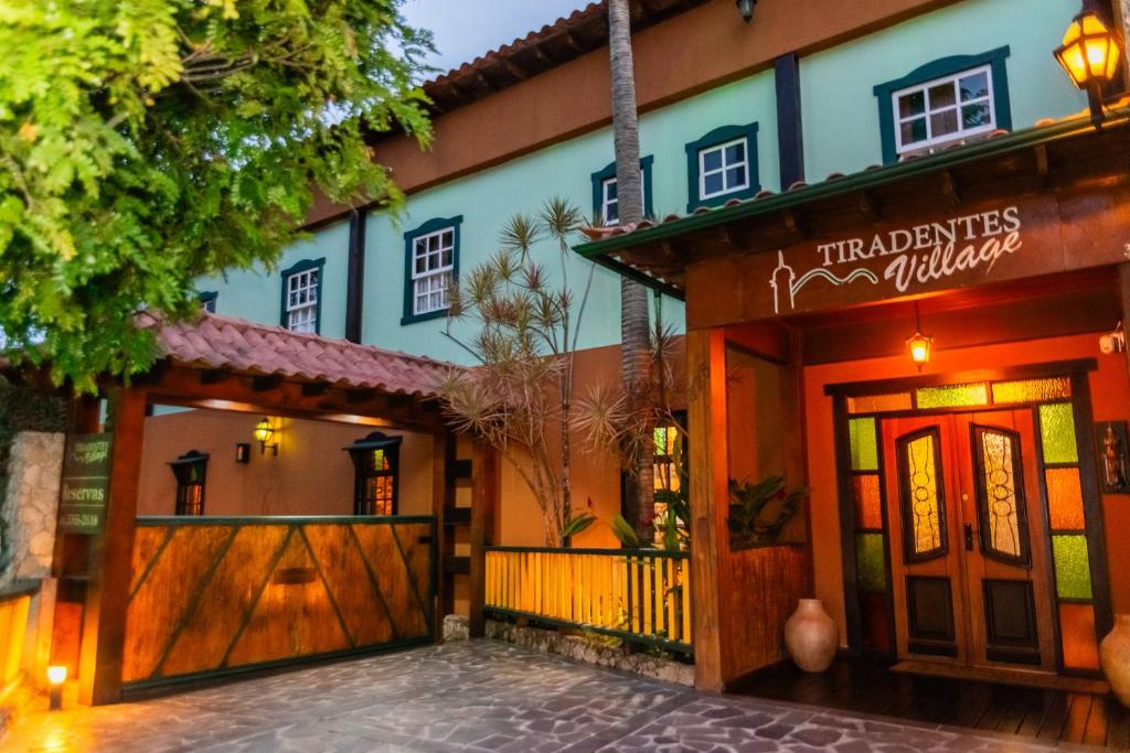a house with a wooden gate and a fence at Tiradentes Village in Tiradentes