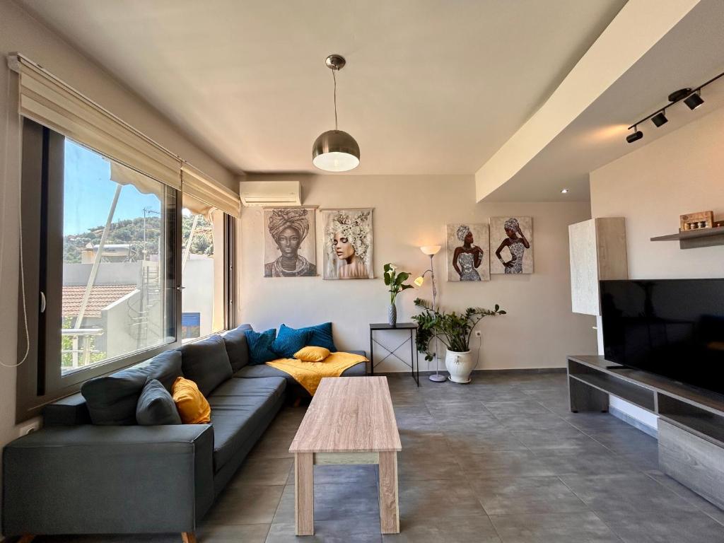 a living room with a couch and a large window at elva creta beach in Palaiokastro