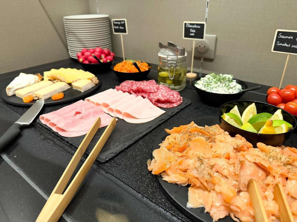a table topped with different types of food on plates at Mercure Rennes Centre Place Bretagne in Rennes