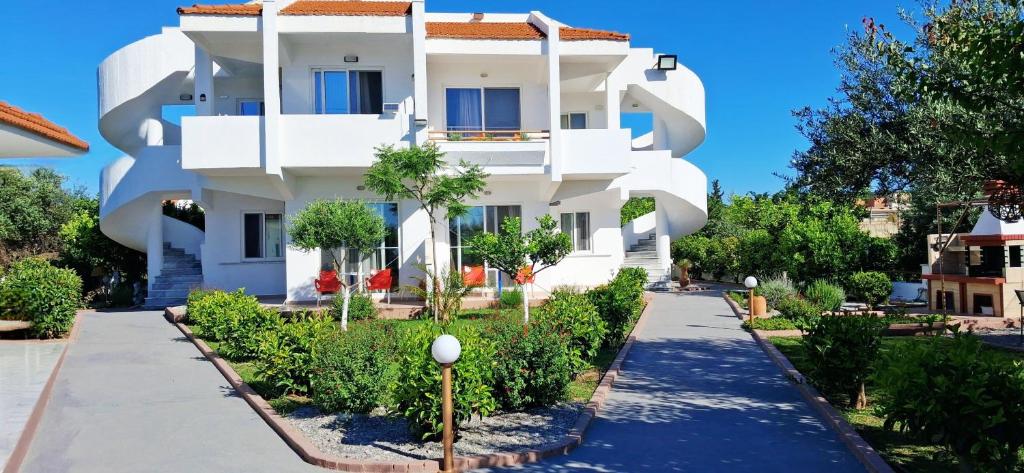 a white building with trees in front of it at Villa Maroula in Afantou