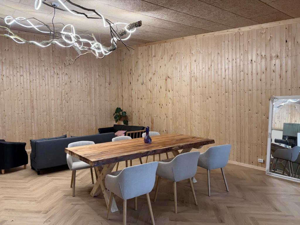 a dining room with a wooden table and chairs at Bornholm Eco Suites in Klemensker