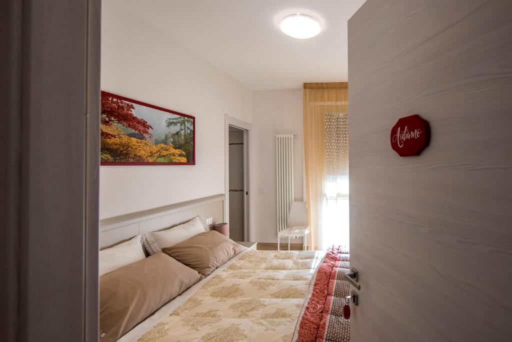 una camera da letto con un letto e un dipinto sul muro di Affittacamere Le Quattro Stagioni a Pisa