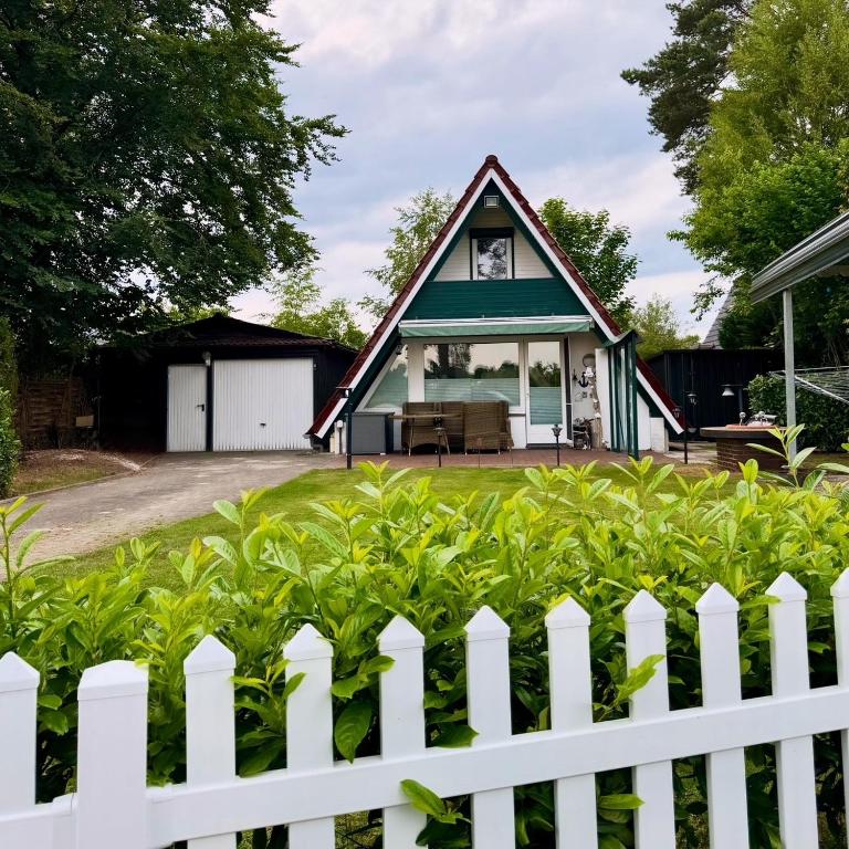 a white picket fence in front of a house at Ferienhaus Conneforde in Wiefelstede