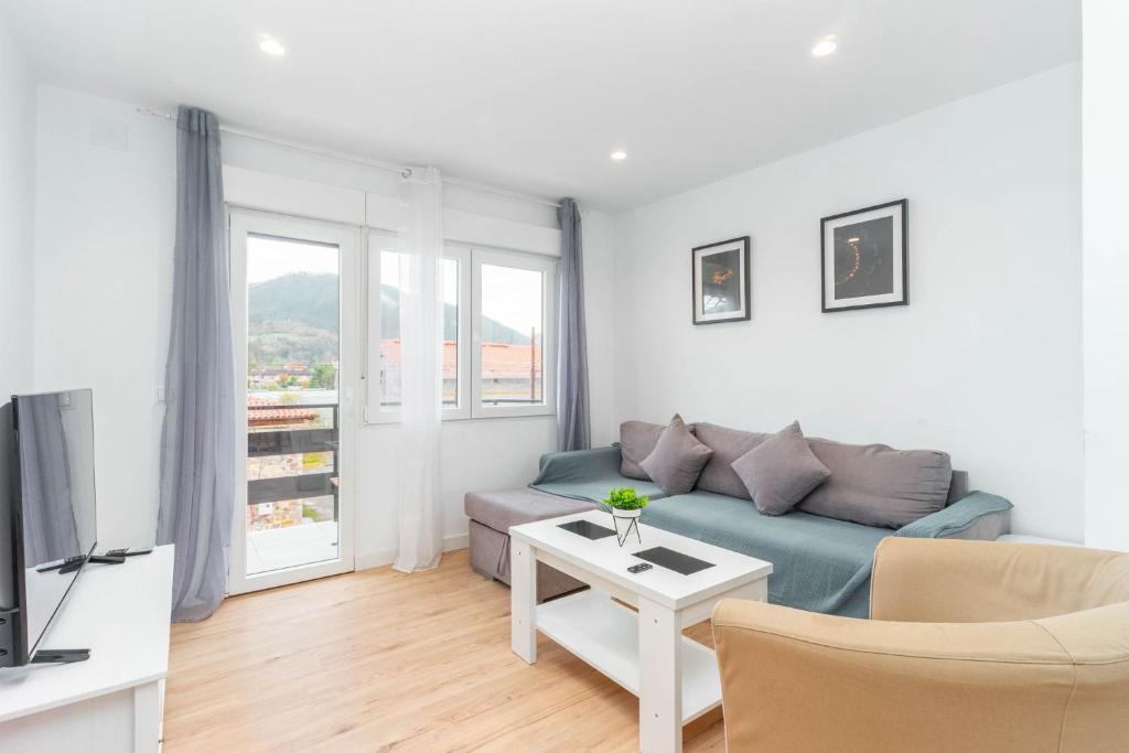 a living room with a couch and a table at Apartamento La Salamandra in Arriondas