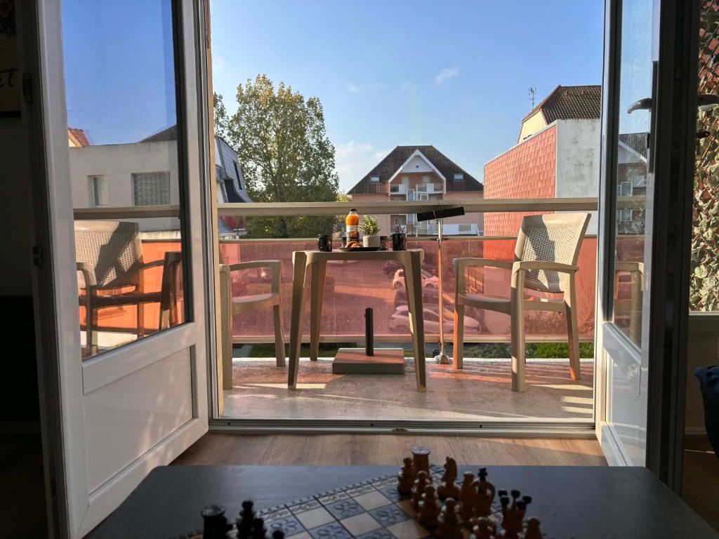 an open door to a balcony with a table at Studio de vacances Stella Plage in Cucq