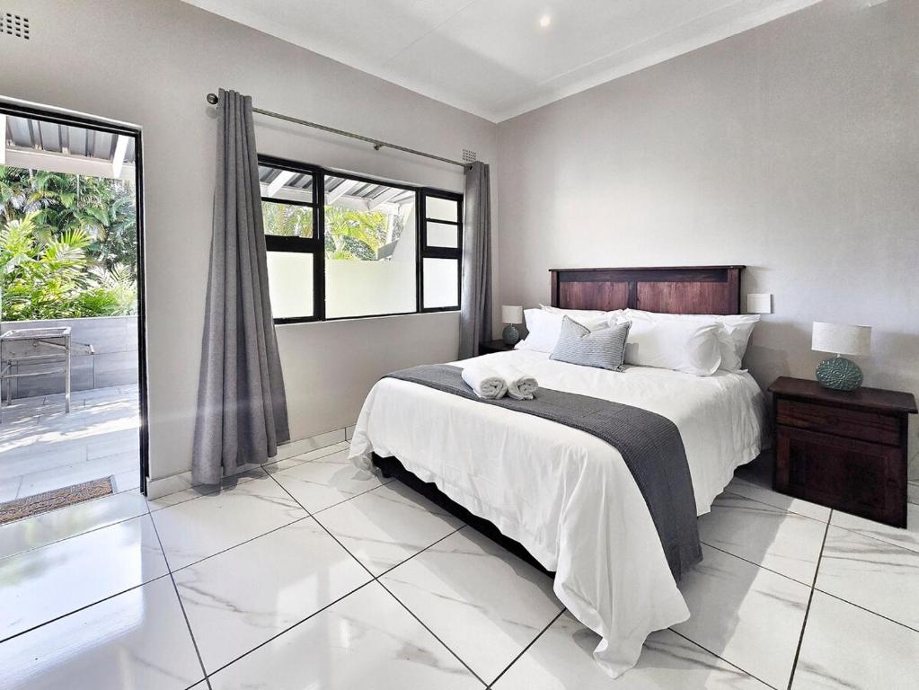 a bedroom with a bed and a large window at Manzini Chalet no20 in St Lucia