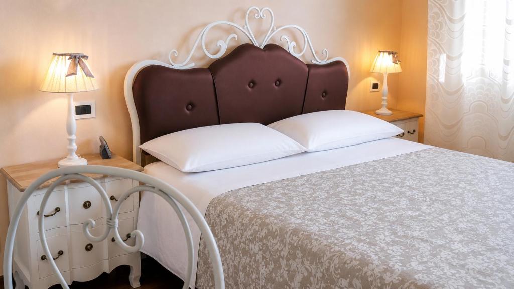 a bedroom with a large bed and two lamps at Villa Bruna in Cesenatico